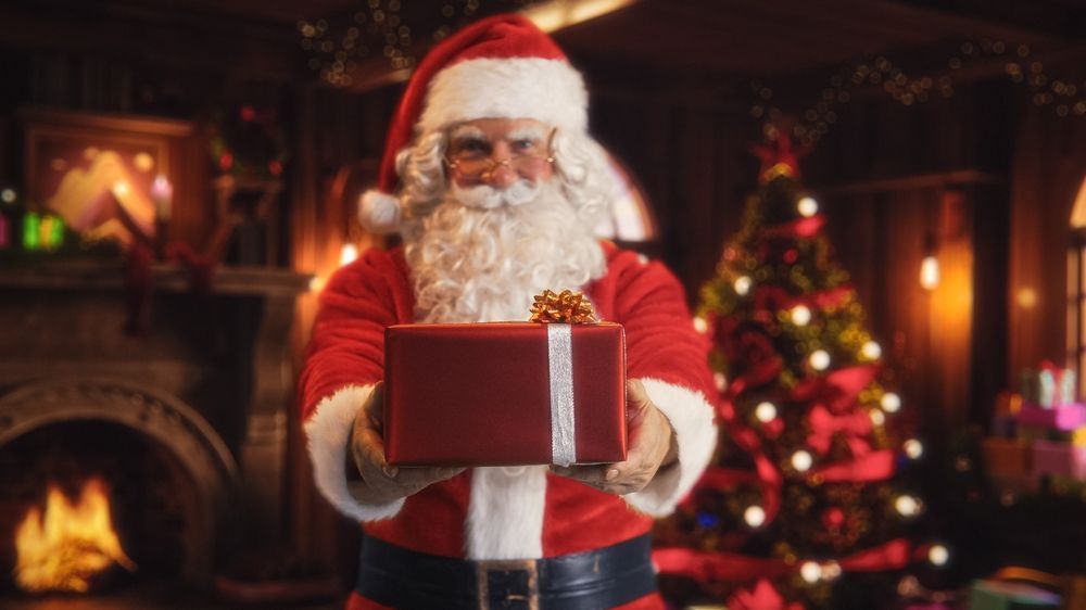 Weihnachtsmann &uuml;berreicht ein Geschenk.